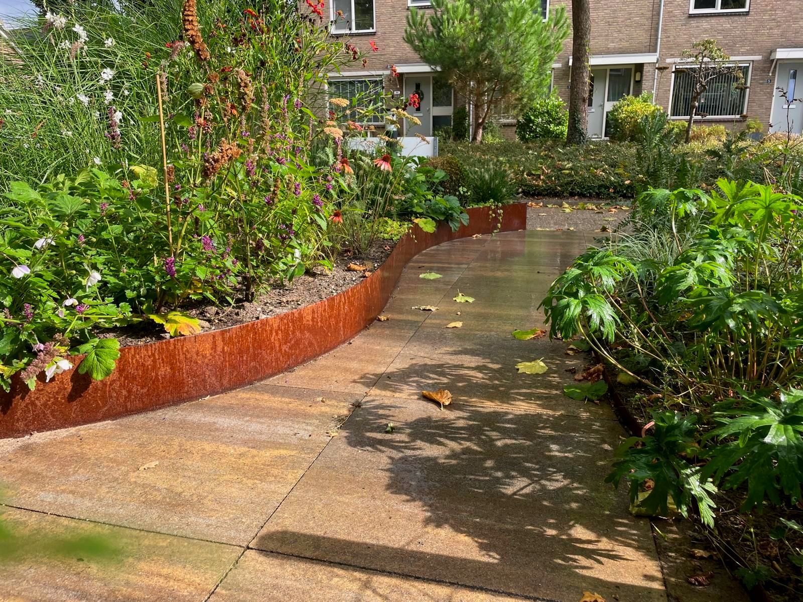 Tuin met gebogen cortenstalen rand met verhoogde border.