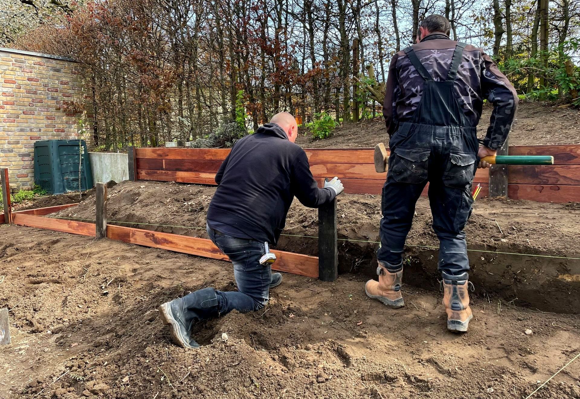 Aanleg van verhoogde borders in een tuin met natuurlijke beplanting.