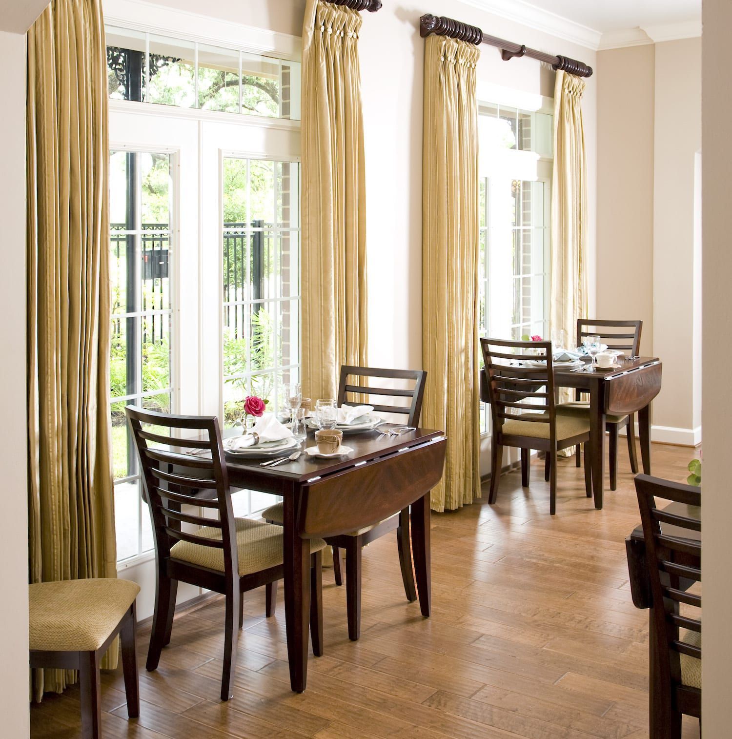 A dining room with tables and chairs and lots of windows