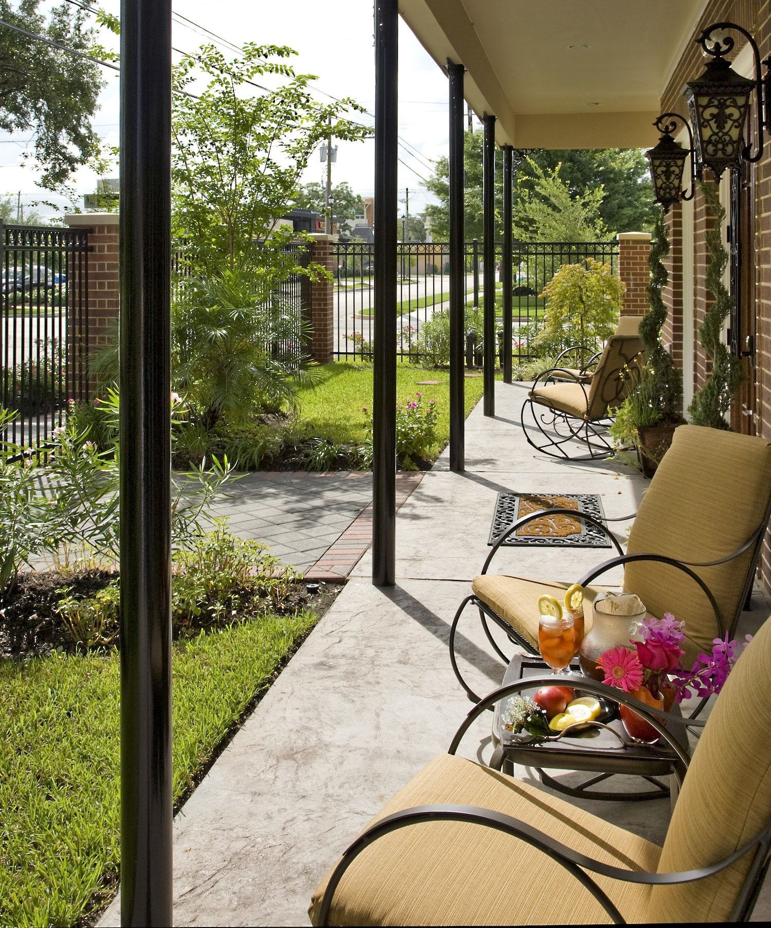 A porch with chairs and a table with flowers on it
