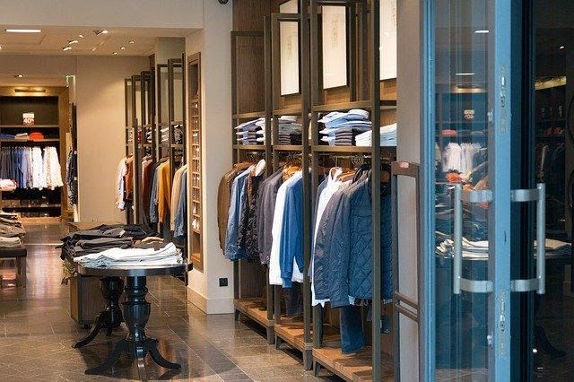 A clothing store filled with lots of clothes and a table.