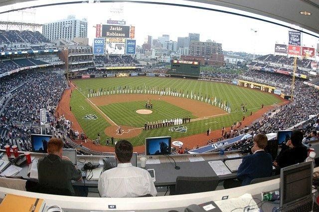 A group of people are watching a baseball game in a stadium