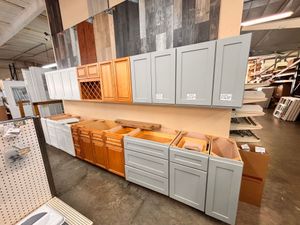 Display of gray and wood kitchen cabinets in a showroom aisle