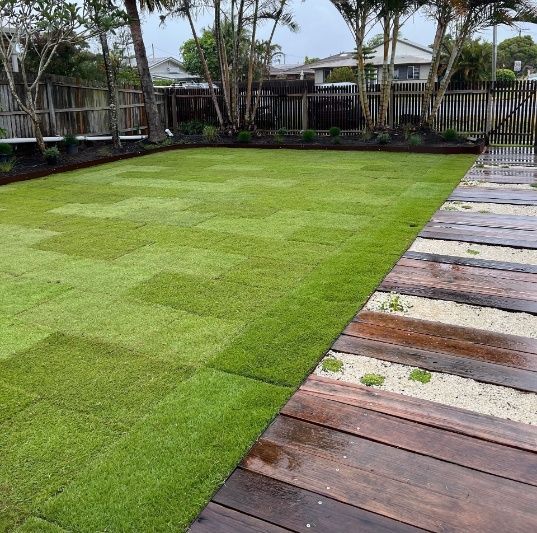 A Wooden Walkway Leading To A Lush Green Lawn — Garden Folk In Suffolk Park, NSW