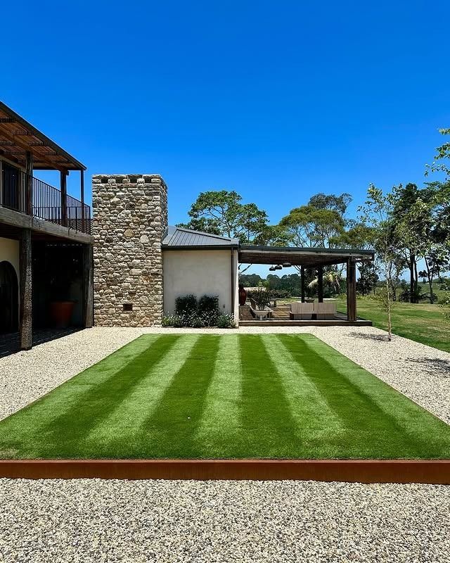 A Man Is Mowing A Lush Green Lawn With A Lawn Mower — Garden Folk In Alstonville, NSW