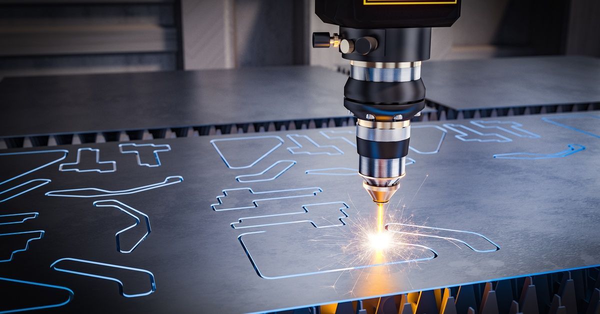 A machine in a manufacturing facility using a precision laser to cut different shapes out of a piece of sheet metal.