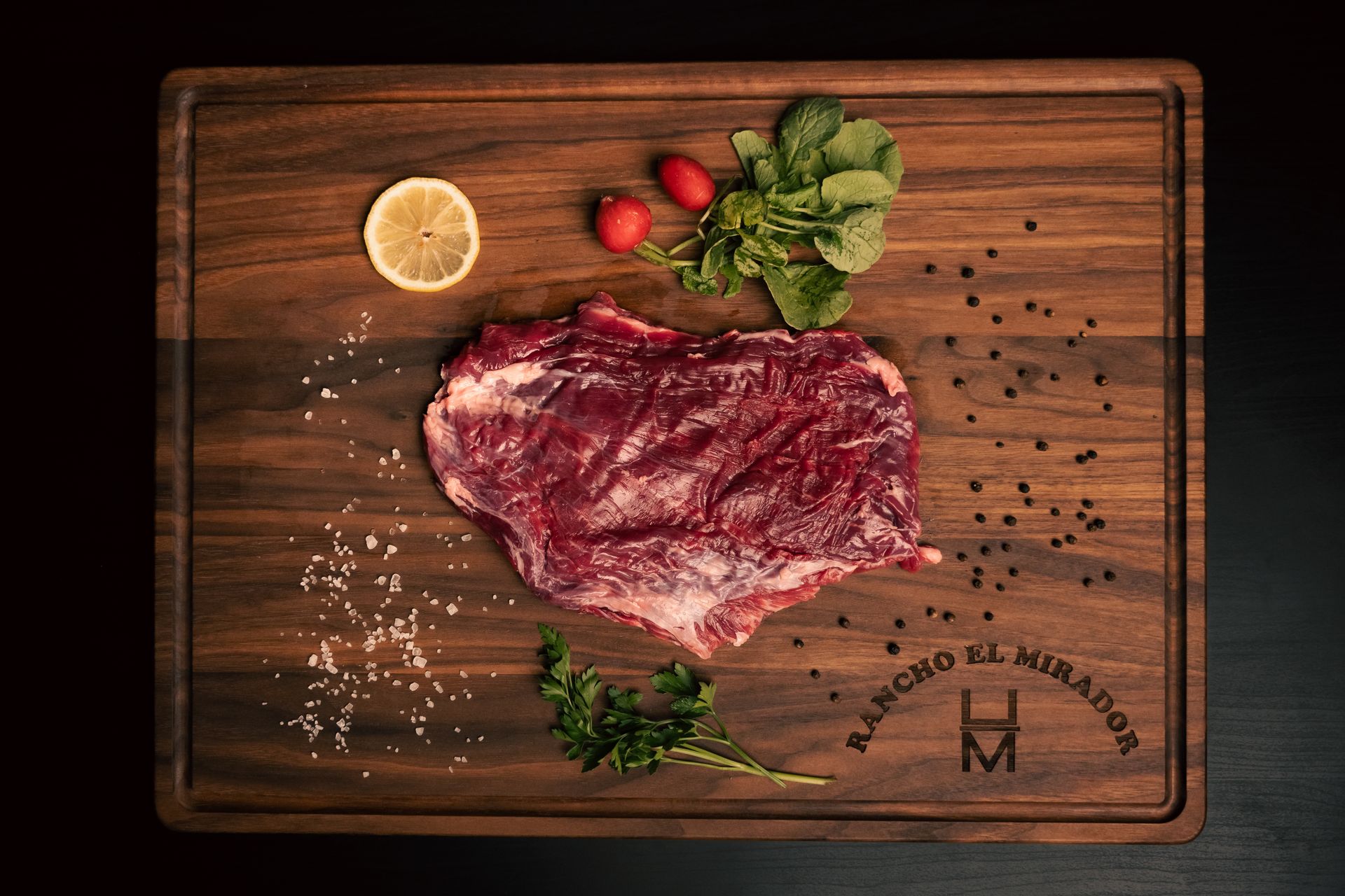 A piece of raw meat is sitting on top of a wooden cutting board.