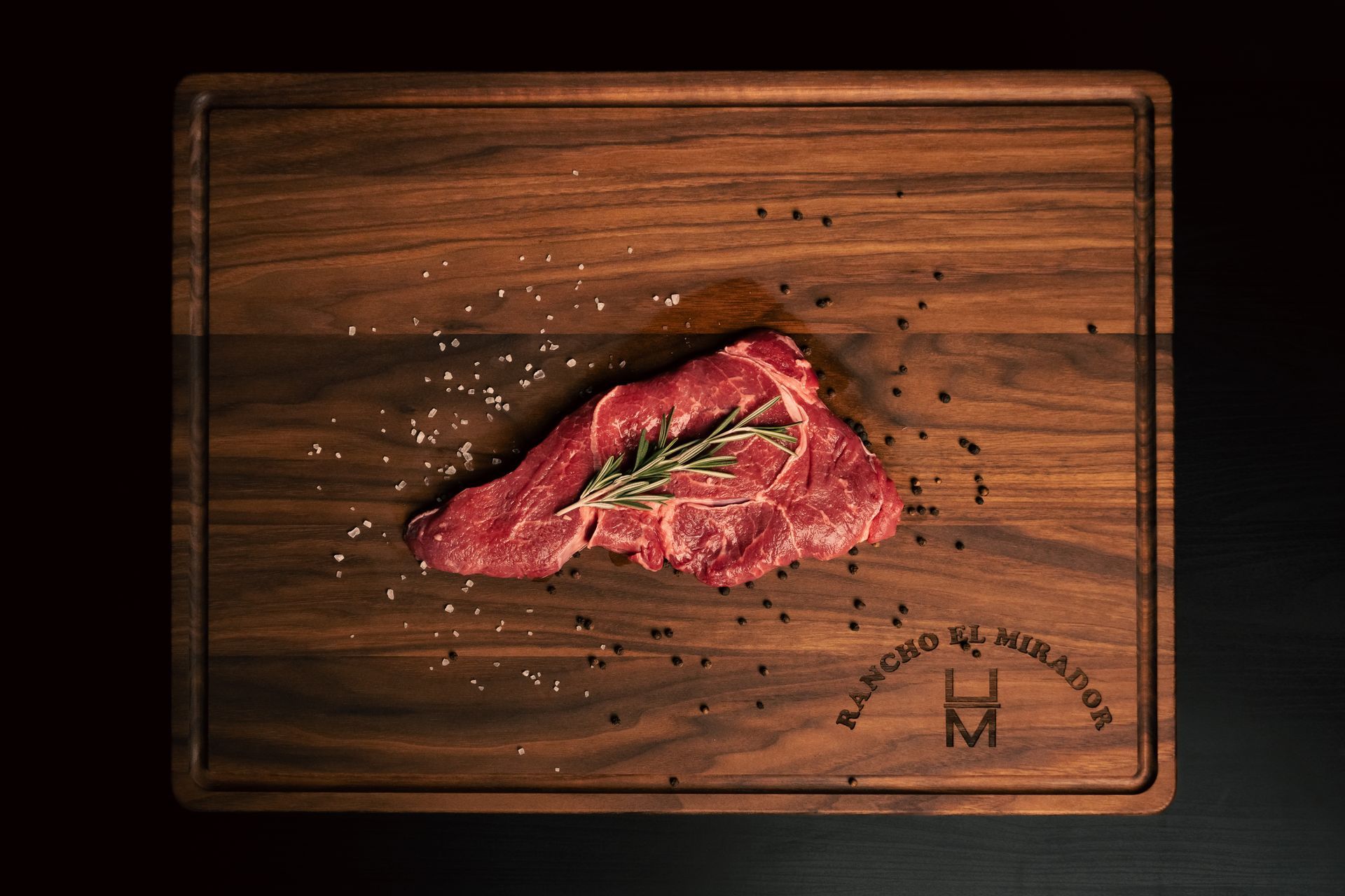 A piece of raw meat is on a wooden cutting board.