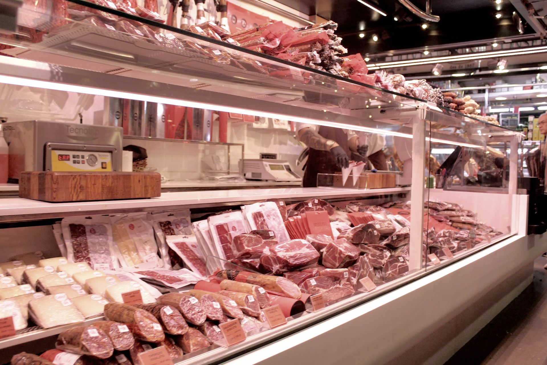 A grocery store display case filled with lots of meats and cheeses.