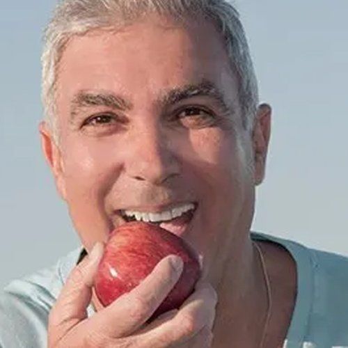 man with nice white teeth eating apple
