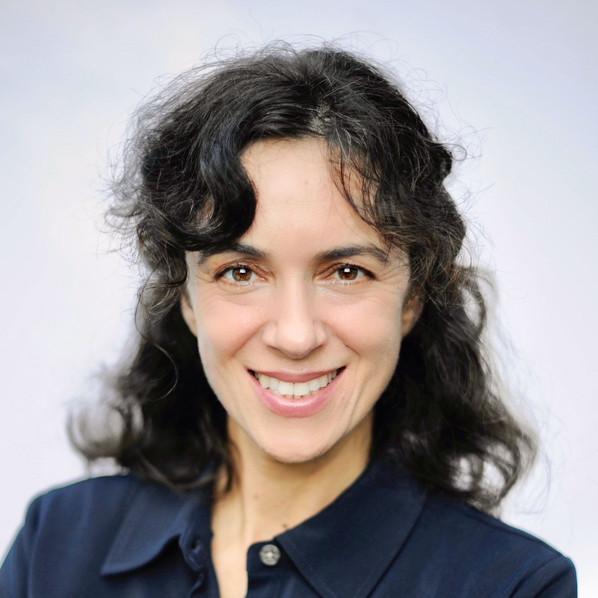 A headshot of Adria Scharf smiling