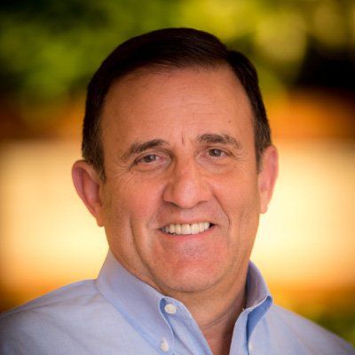 A man in a blue shirt is smiling for the camera.