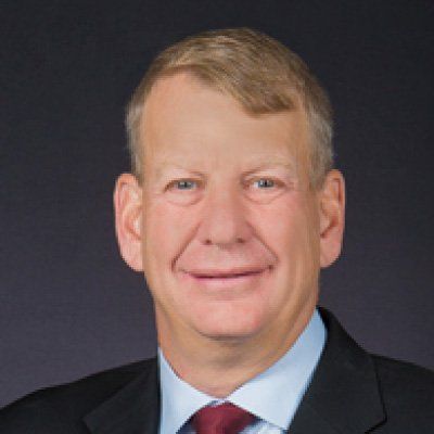 A man in a suit and tie is smiling for the camera