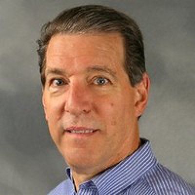 A man in a blue striped shirt is smiling for the camera.
