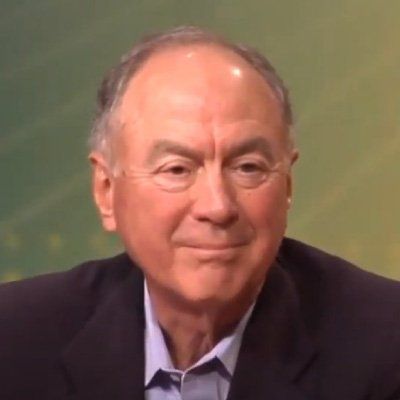 A man in a suit and blue shirt is smiling for the camera.