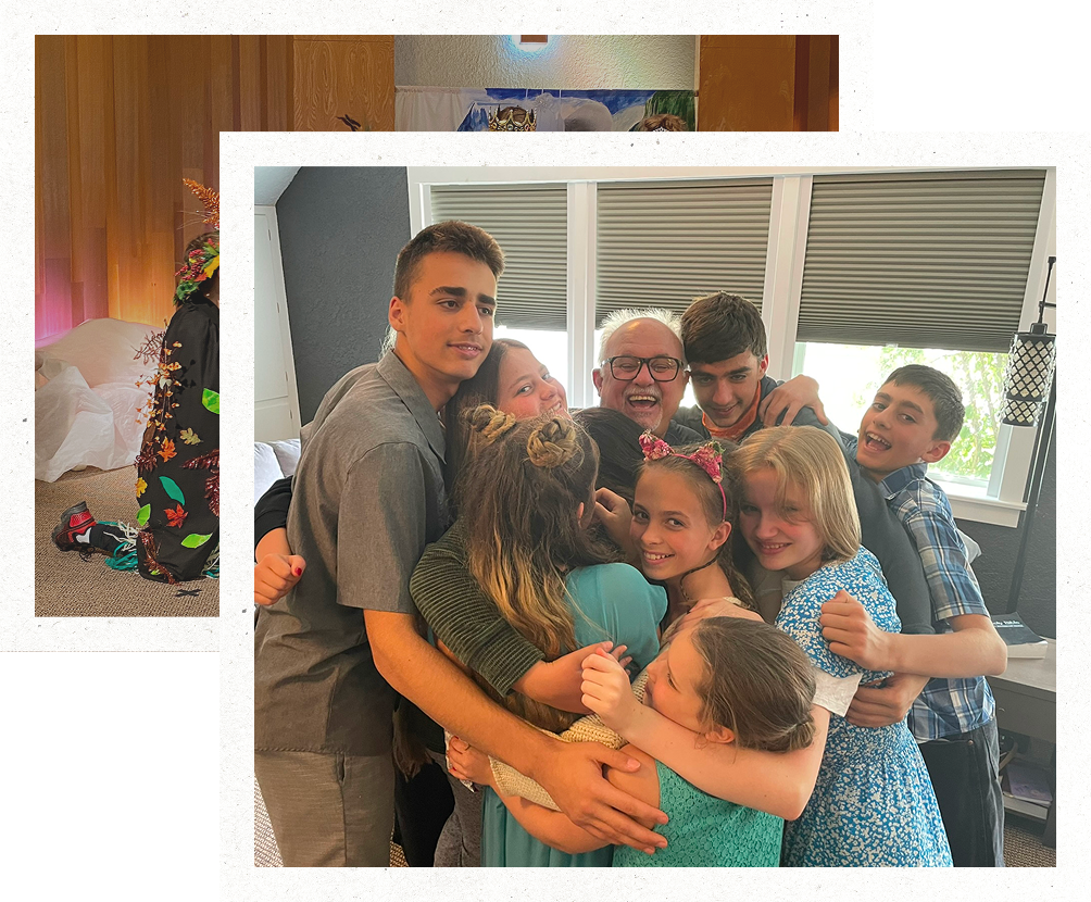 Group of smiling people hugging in a bright room with windows.