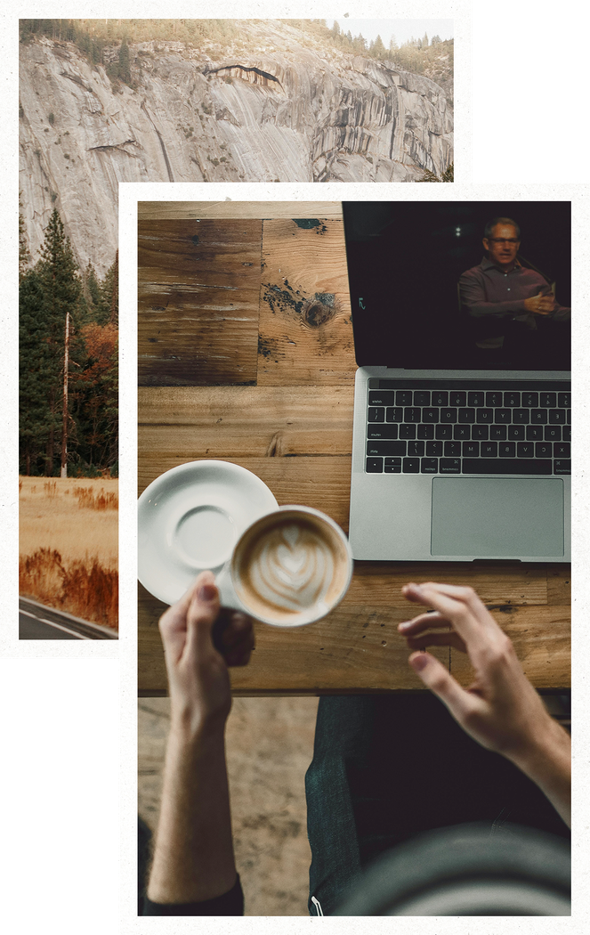 Hands holding a coffee cup beside a laptop on a wooden table, viewed from above.