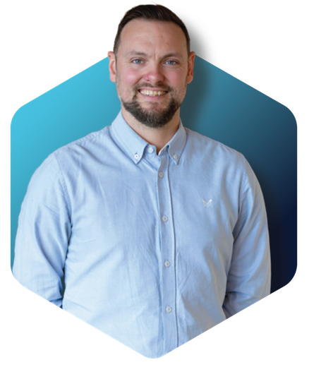 Smiling man in a light blue shirt against a blue hexagonal background