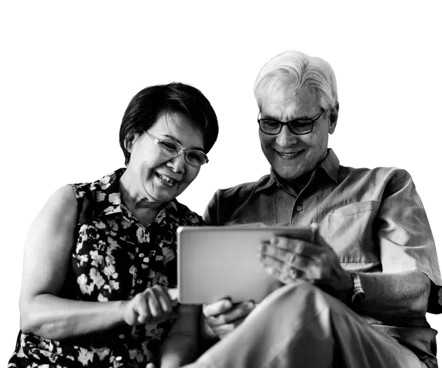 Older adults looking at a tablet, smiling.