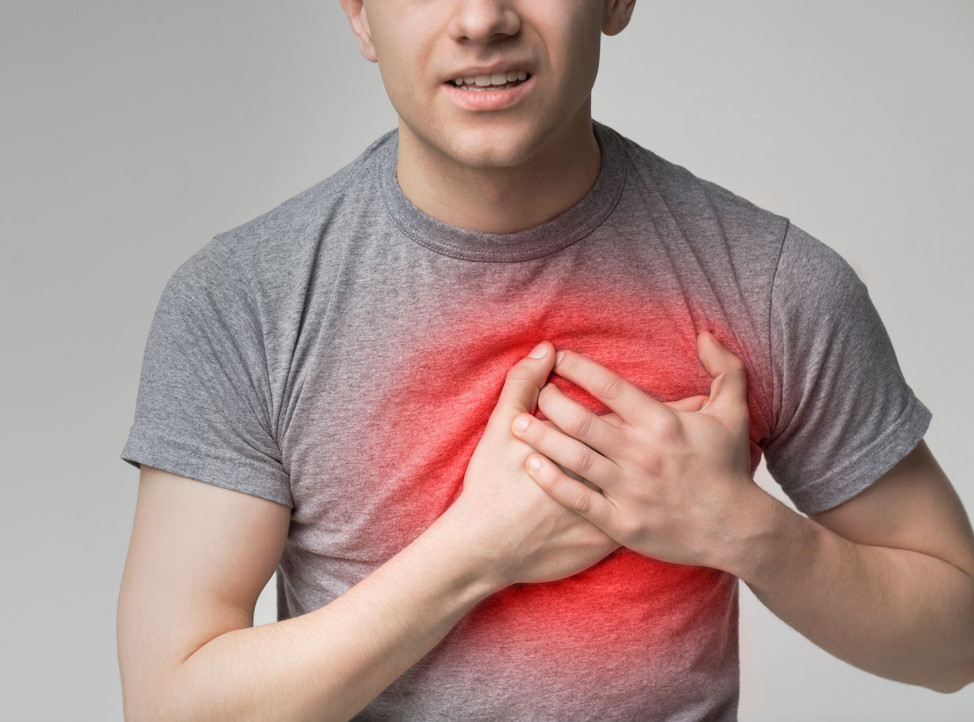 Man clutching chest, showing pain.