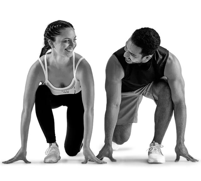 Two people in athletic attire in a starting stance, smiling and looking at each other. Two people in athletic attire in a starting stance, smiling and looking at each other.