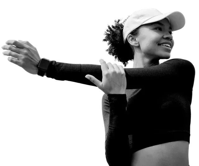 Woman stretching arm, wearing a cap and smiling.