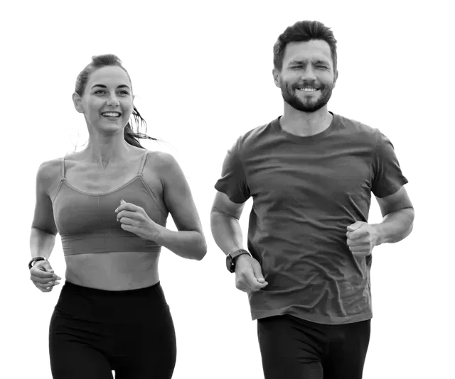 Woman and man running side-by-side, smiling, outdoors.