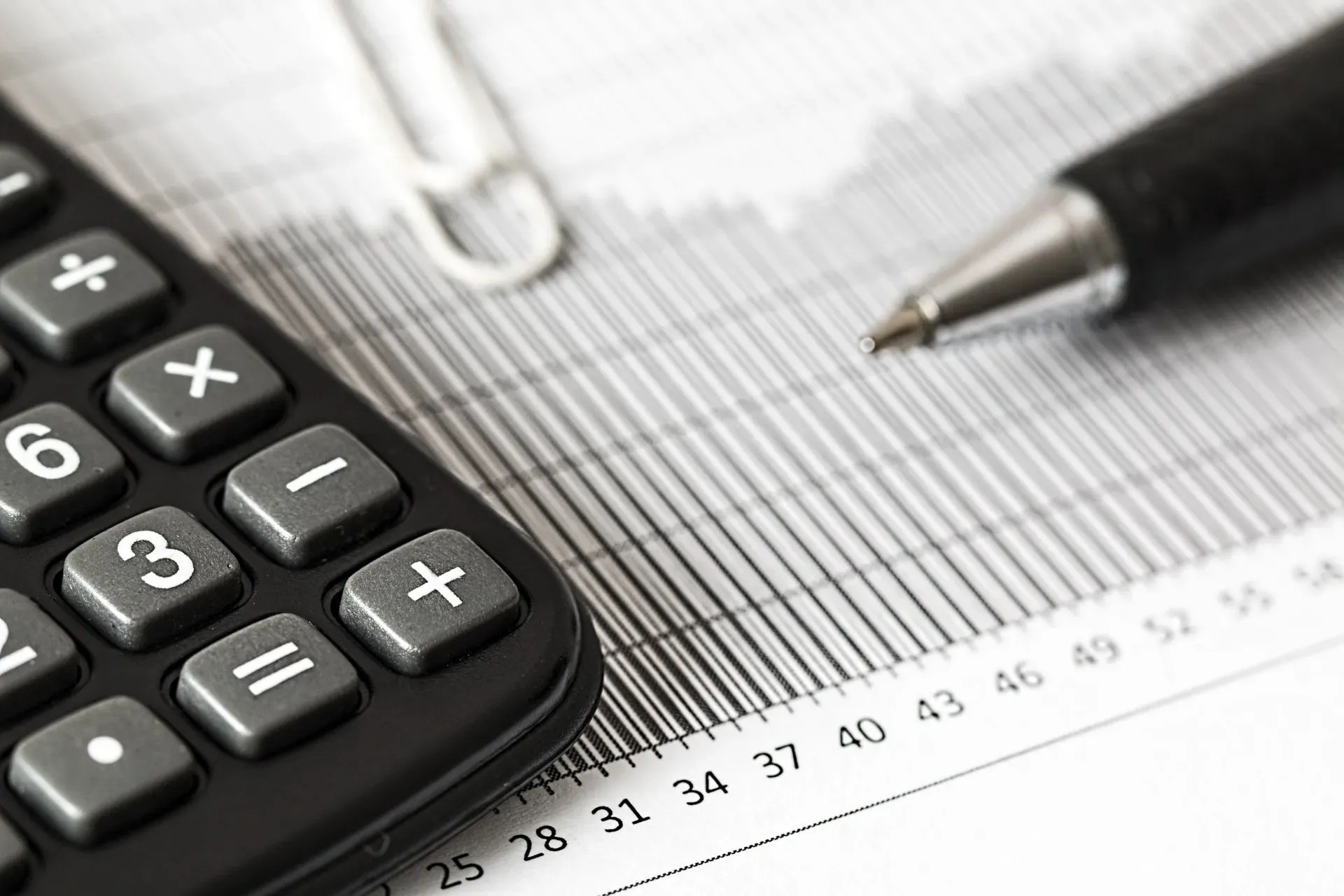 A calculator is sitting on top of a graph next to a pen