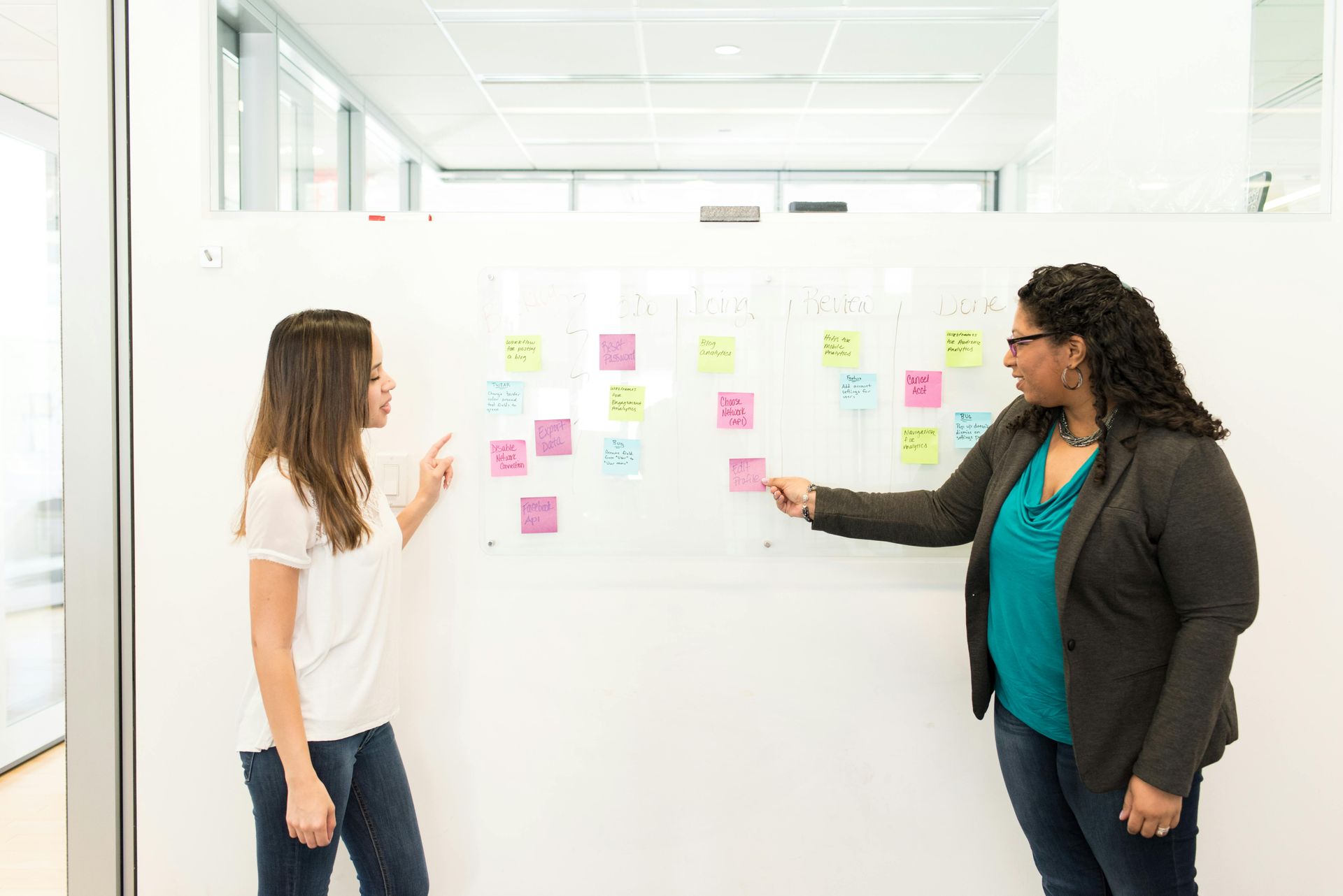 A business professional reviewing a project prioritization matrix on a whiteboard