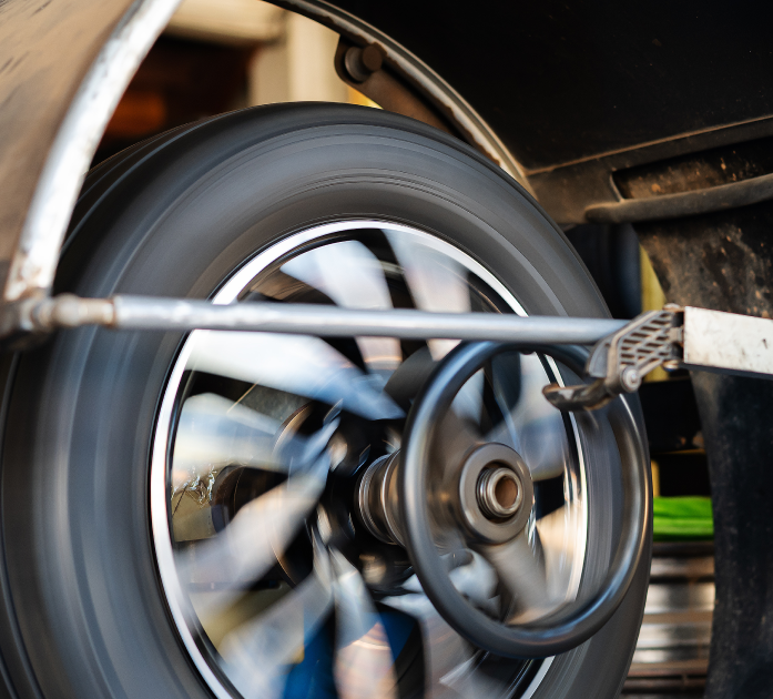Close-up of a blurred spinning wheel and suspension on a vehicle