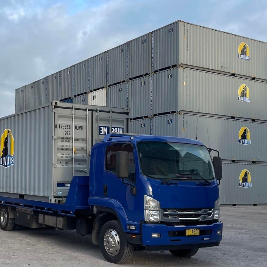 A Truck is Parked in Front of a Stack of Containers — Quick Hitch Towing & Tilt Tray Services in Oak Flats, NSW