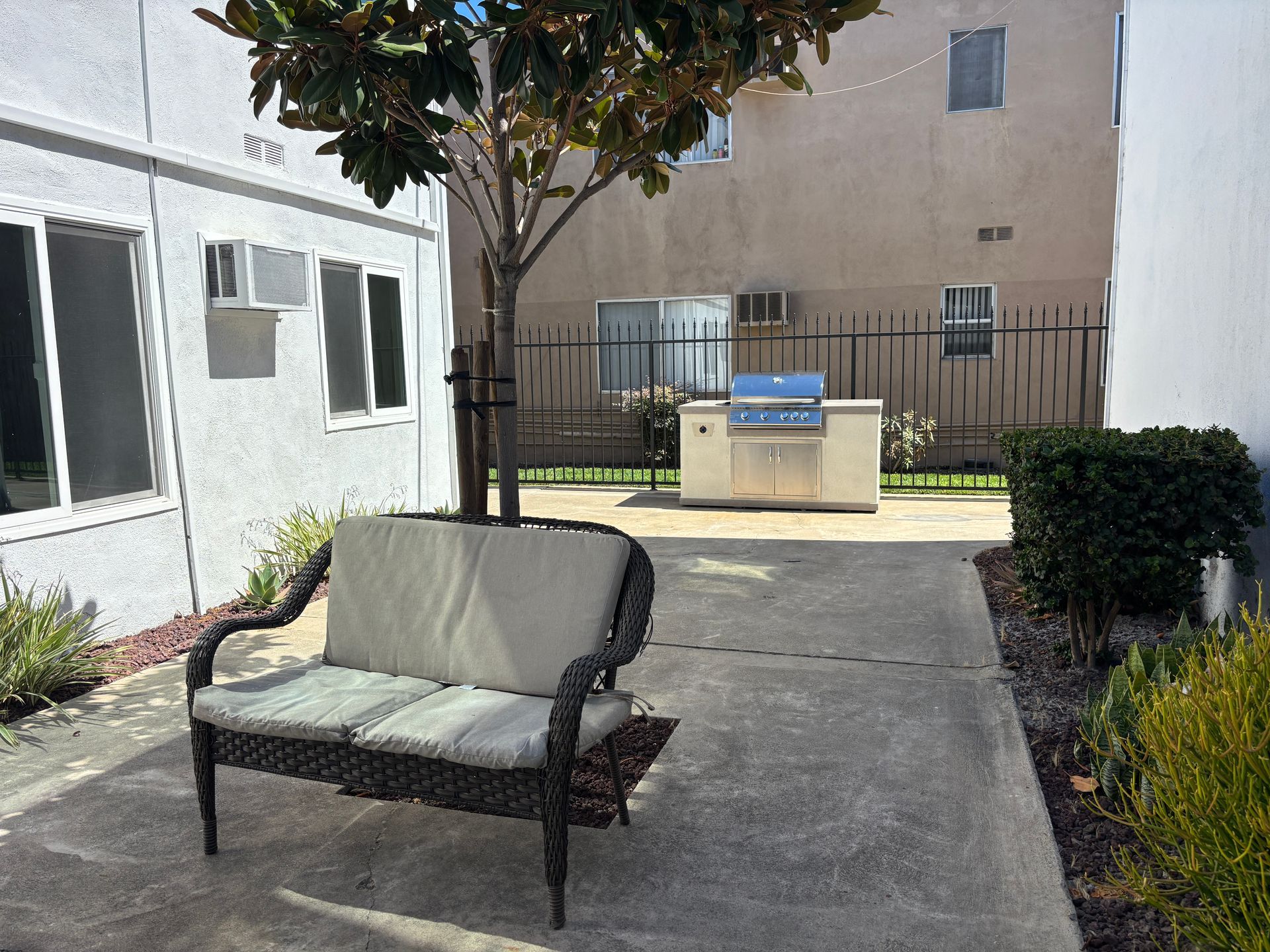 Photo of an apartment community courtyard, showing an outdoor grill