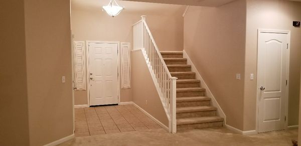 A hallway with stairs leading up to the second floor of a house.