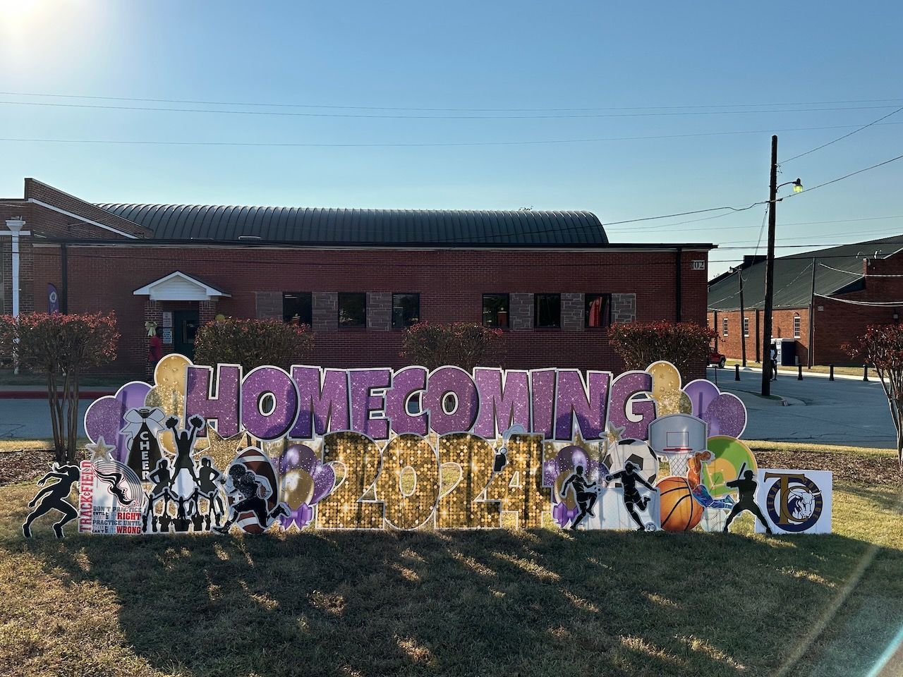 A large sign that says homecoming is in front of a building.