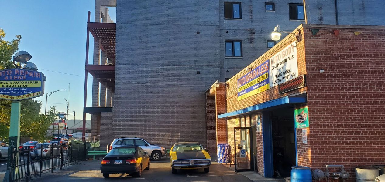 A car repair shop with cars parked in front of it