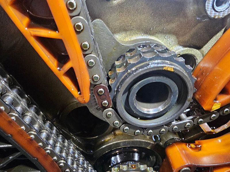 A close up of a chain on a motorcycle engine