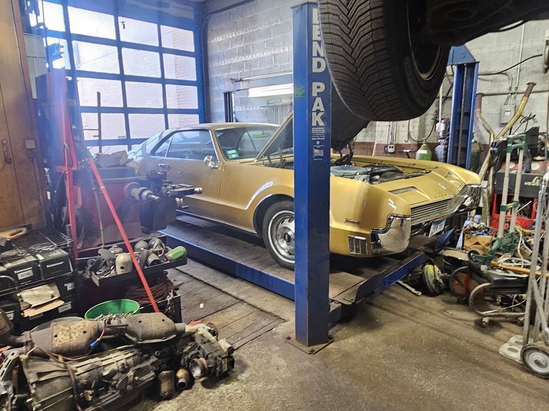 A car is sitting on a lift in a garage.