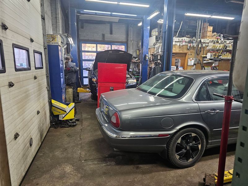 A car is parked in a garage next to a garage door.
