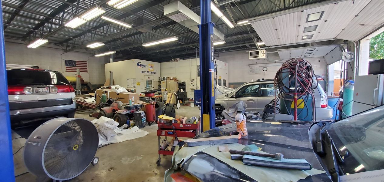 A car is sitting on a lift in a garage.