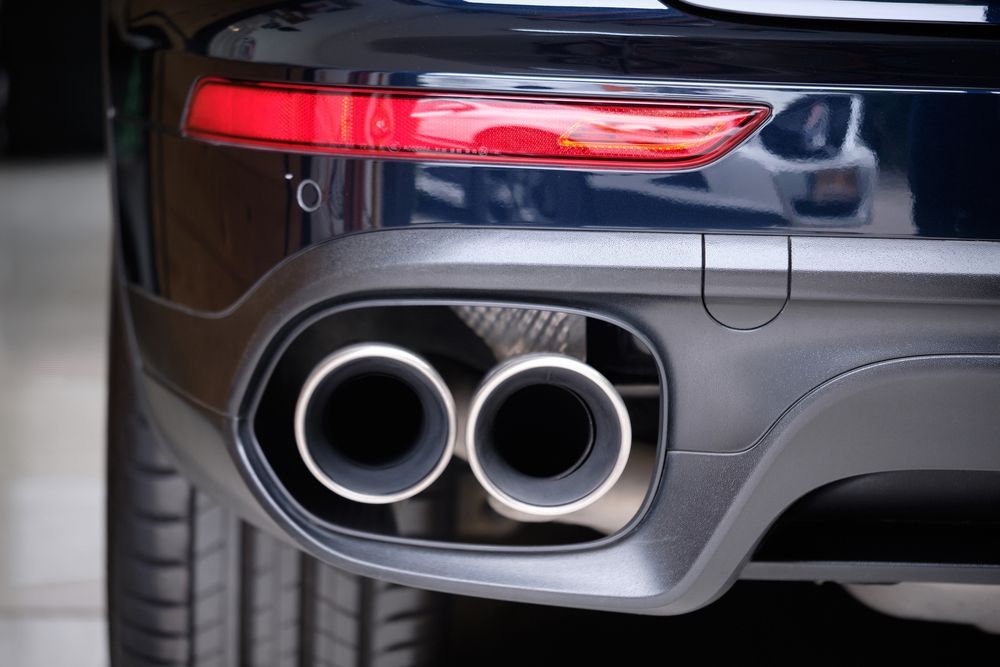 A close up of the exhaust pipes of a black car.