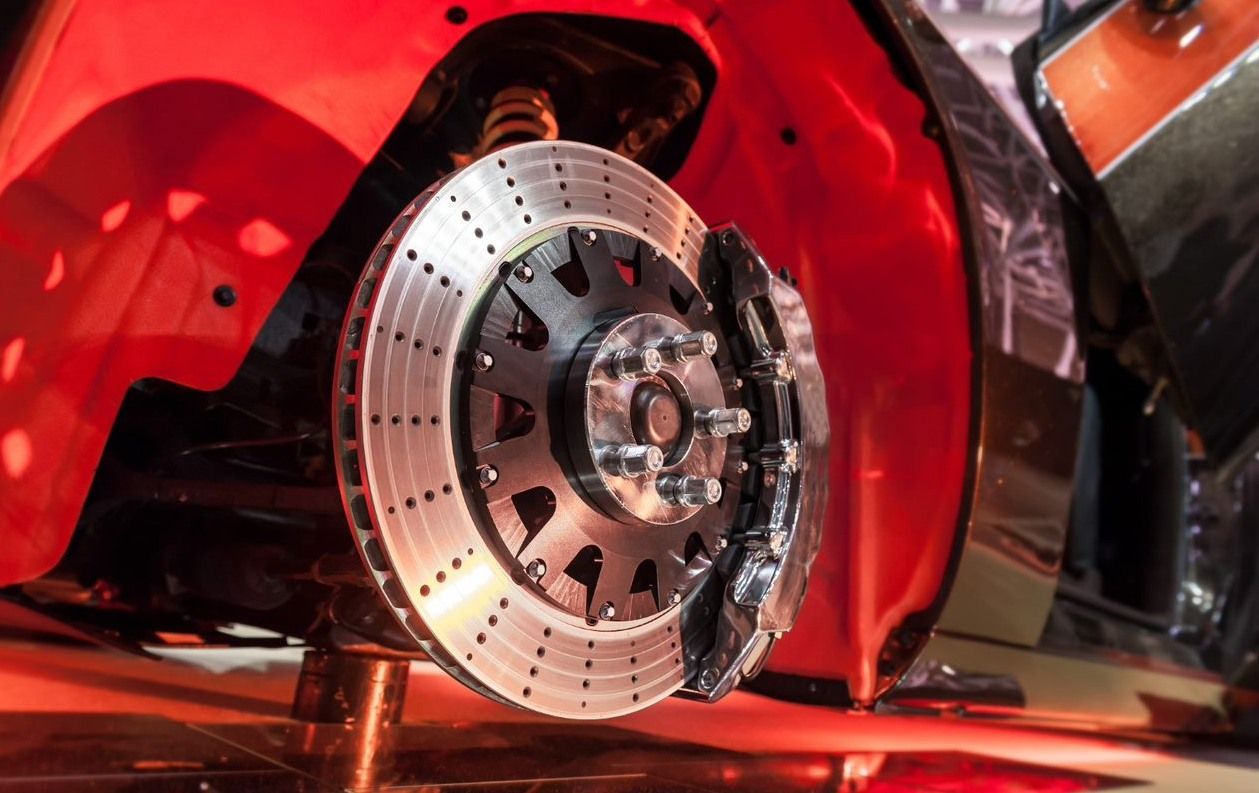 A close up of a brake disc on a red car