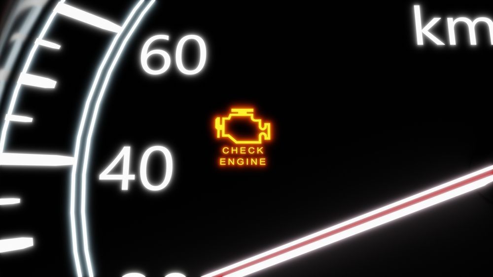 A check engine light is lit up on the dashboard of a car