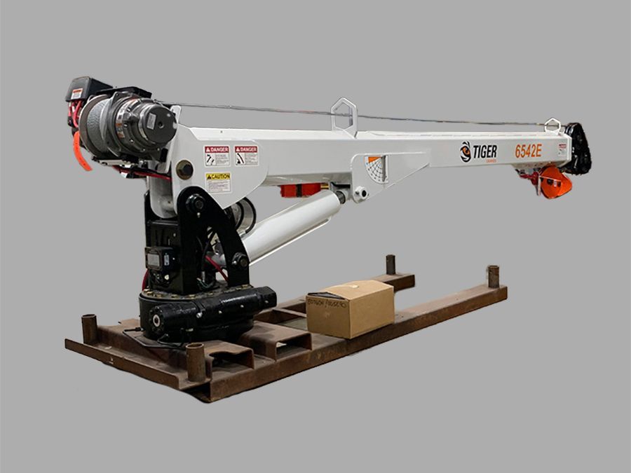 A white truck-mounted crane on a steel platform with a box.
