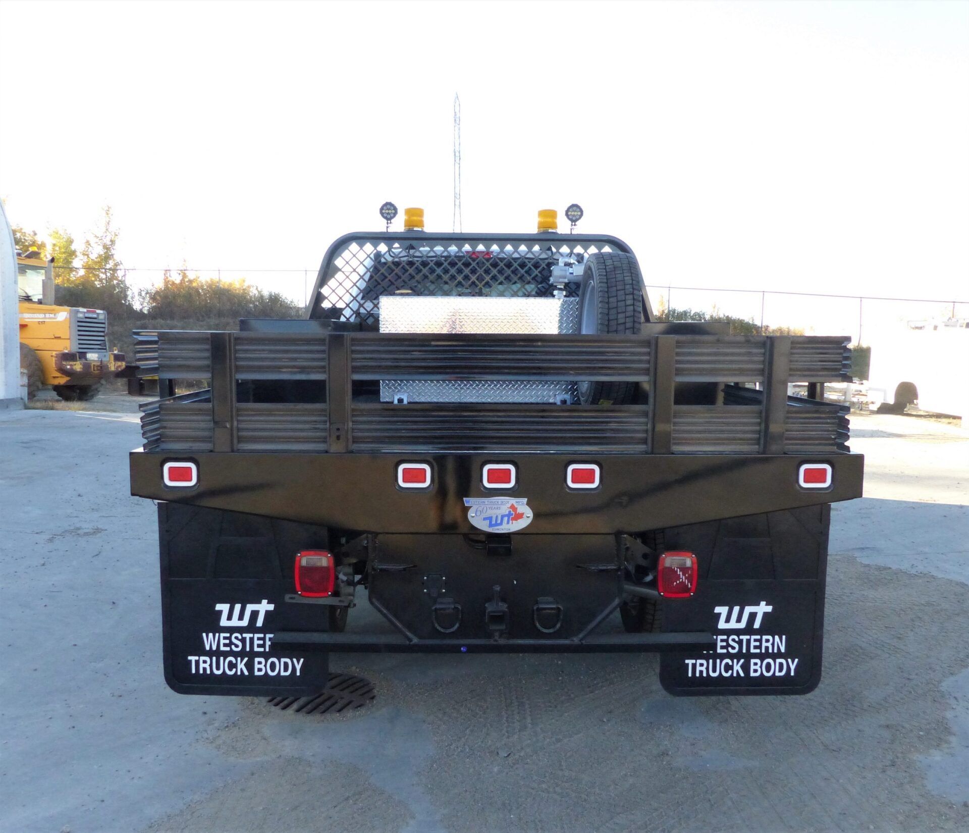 Rear view of a black flatbed utility truck with