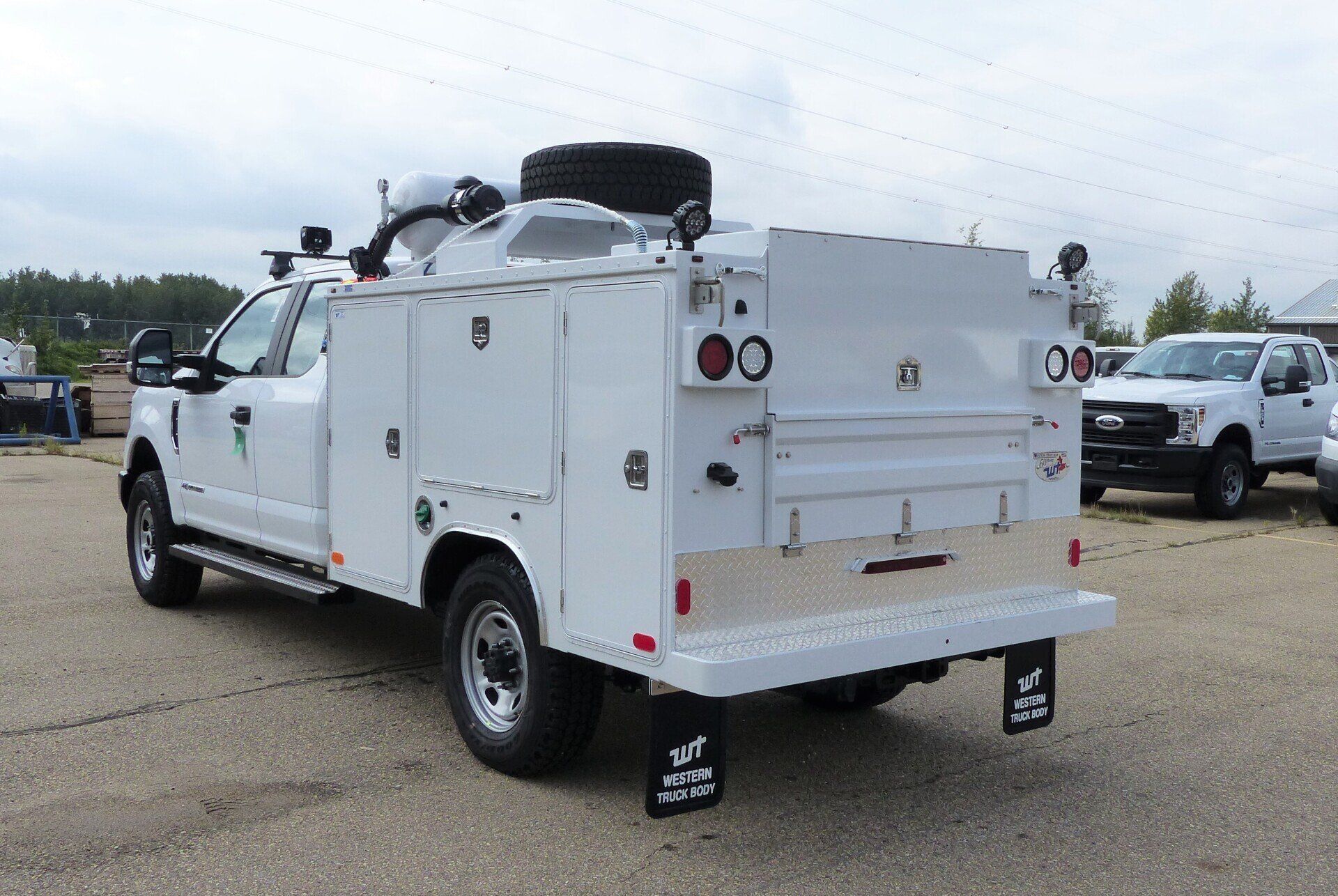 A white utility truck is parked in a parking lot.