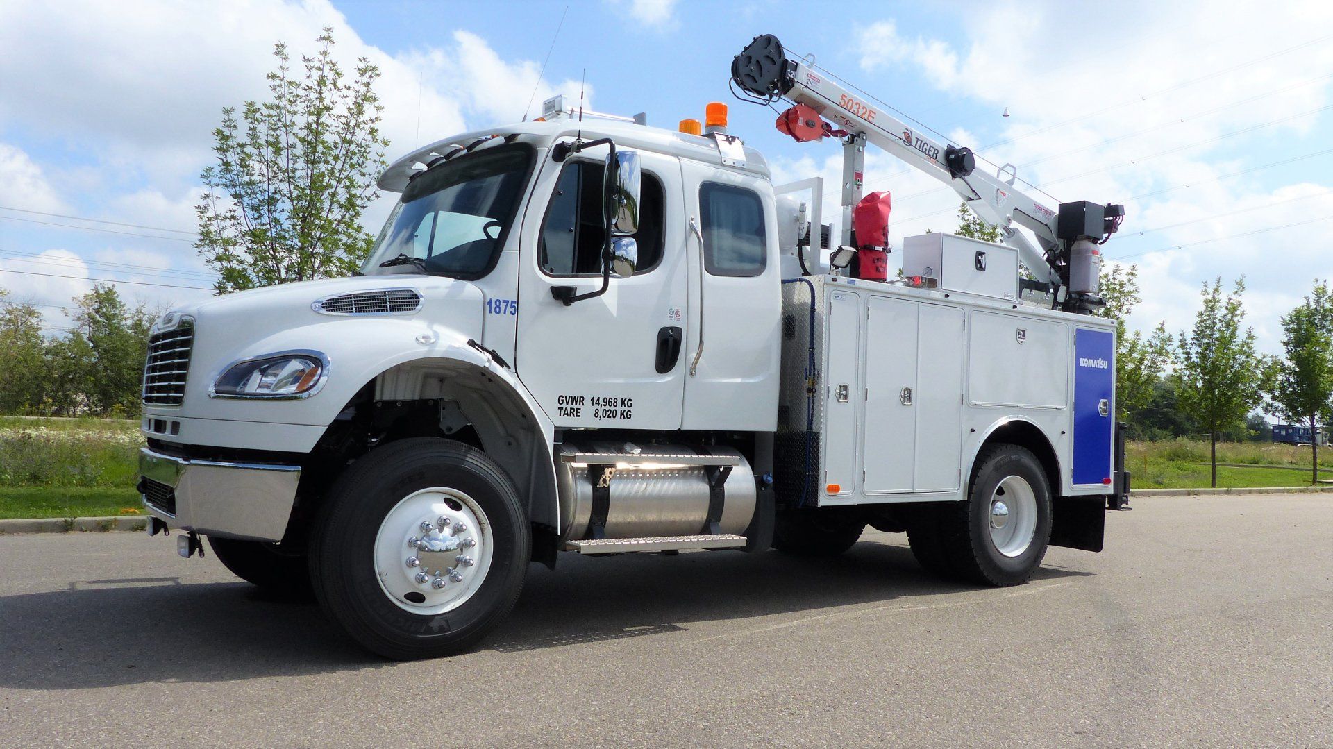 White utility truck with crane boom, parked on pavement.