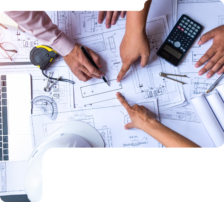Hands and tools reviewing architectural blueprints on a desk with a calculator and ruler