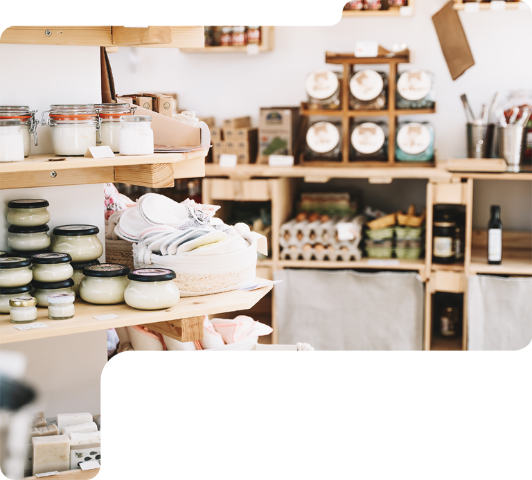 Bright shop display with jars, candles, and stacked white towels on wooden shelves