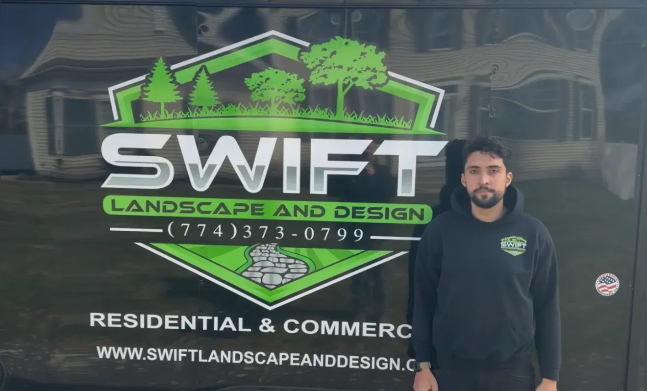 Man standing beside a Swift Landscape and Design truck with green logo and website text.
