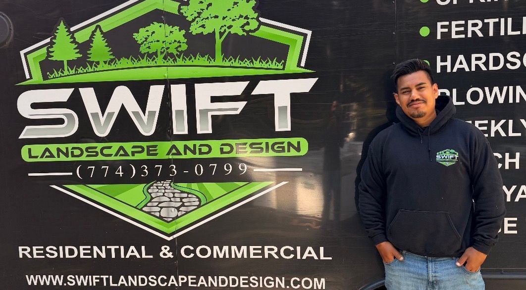 Swift Landscape and Design sign with green logo; man in black hoodie stands beside it.